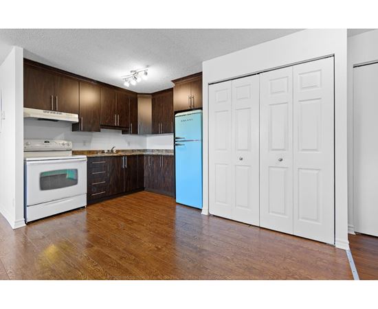 A kitchen with a white oven and a blue refrigerator.