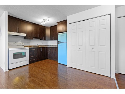 A kitchen with a white oven and a blue refrigerator.