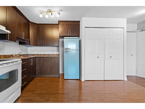 A kitchen with a white oven and brown cabinets.