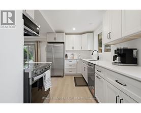A modern kitchen with white cabinets and stainless steel appliances.