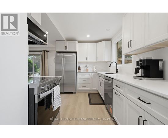 A modern kitchen with white cabinets and stainless steel appliances.