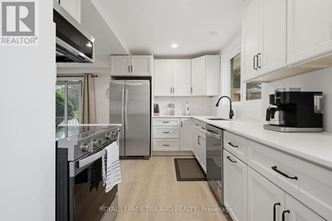 A modern kitchen with white cabinets and stainless steel appliances.