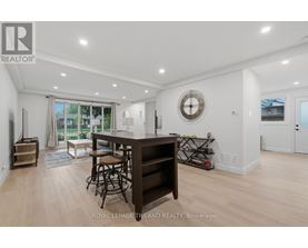 A well-lit, spacious living room with a bar area and a view of the outdoors.
