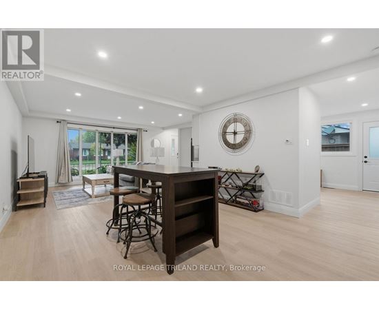 A well-lit, spacious living room with a bar area and a view of the outdoors.