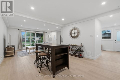 A well-lit, spacious living room with a bar area and a view of the outdoors.
