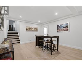 A spacious room with a bar and two paintings on the wall.