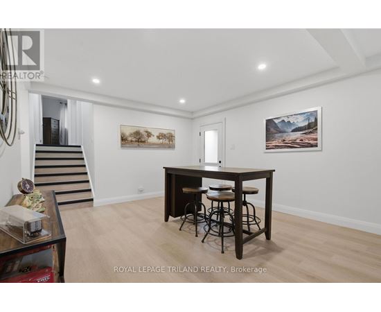 A spacious room with a bar and two paintings on the wall.