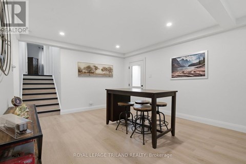 A spacious room with a bar and two paintings on the wall.