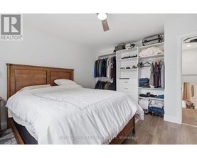 A bedroom with a bed, a closet, and a mirror.