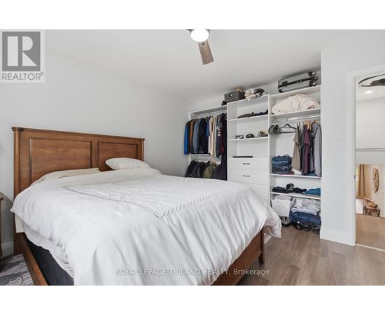 A bedroom with a bed, a closet, and a mirror.