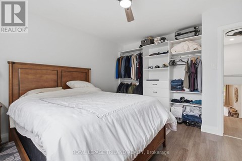 A bedroom with a bed, a closet, and a mirror.