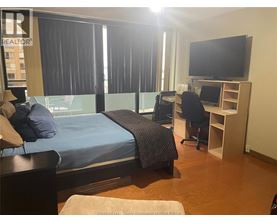A bedroom with a bed, desk, and chair.