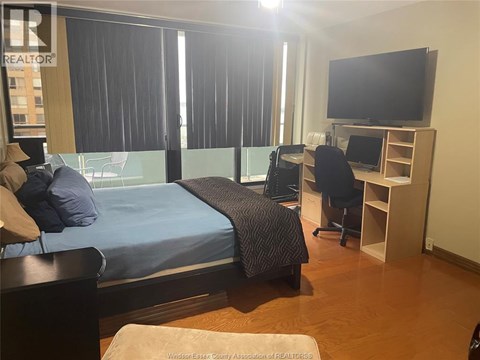 A bedroom with a bed, desk, and chair.