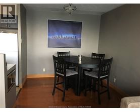A dining room with a table and chairs.