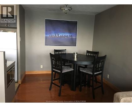 A dining room with a table and chairs.