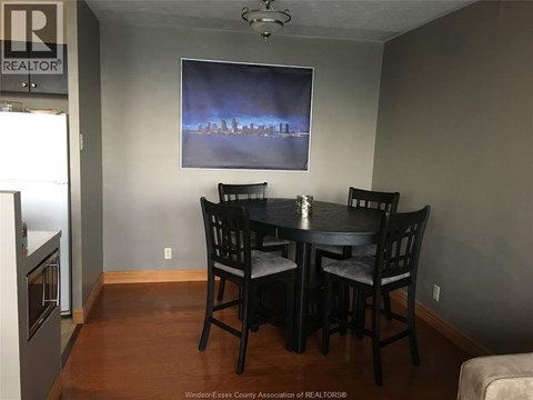 A dining room with a table and chairs.