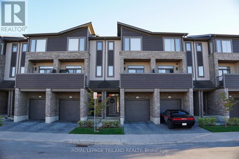 A black car is parked in front of a building with a sign that says "Royal LePage Triland Realty, Brokerage.".