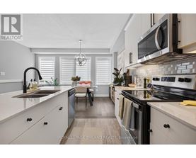 A modern kitchen with white cabinets and black appliances.