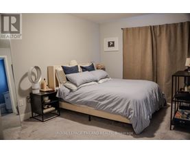 A bedroom with a bed, nightstand, and lamp.