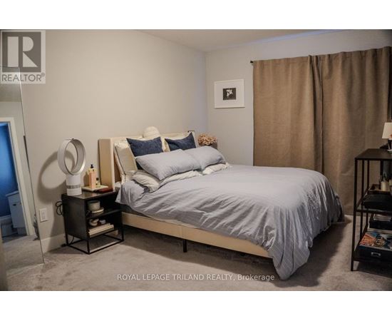 A bedroom with a bed, nightstand, and lamp.