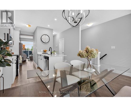 A modern kitchen with a glass table and white chairs.