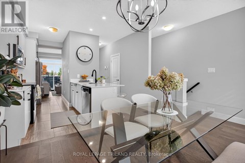 A modern kitchen with a glass table and white chairs.