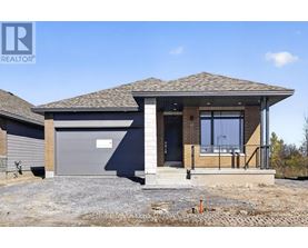 A house with a grey garage door is for sale.