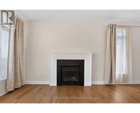 A living room with a fireplace and beige curtains.