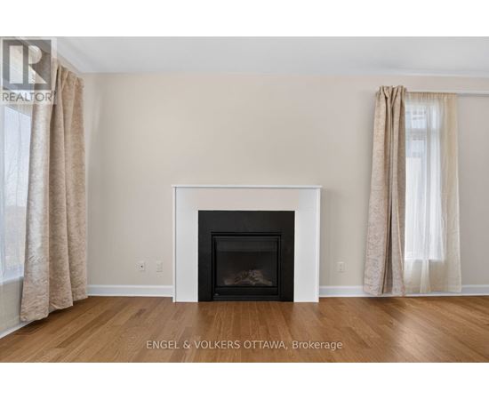 A living room with a fireplace and beige curtains.
