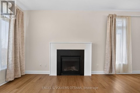 A living room with a fireplace and beige curtains.