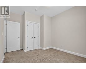 A bedroom with two doors and a carpeted floor.