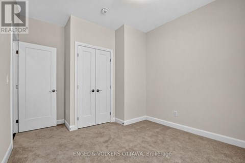 A bedroom with two doors and a carpeted floor.