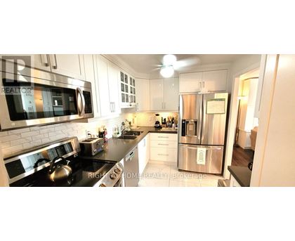 A modern kitchen with a stainless steel refrigerator and a stove top oven.