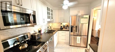 A modern kitchen with a stainless steel refrigerator and a stove top oven.