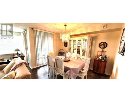 A dining room with a table set for four and a chandelier hanging from the ceiling.