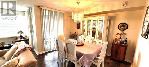 A dining room with a table set for four and a chandelier hanging from the ceiling.
