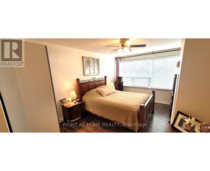 A bedroom with a bed, nightstand, and window.