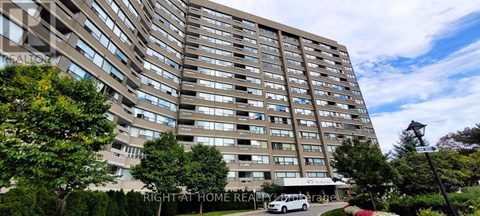 A tall residential building with a car parked in front.