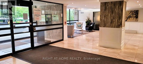 The lobby of a building with a glass wall and a brown pillar.