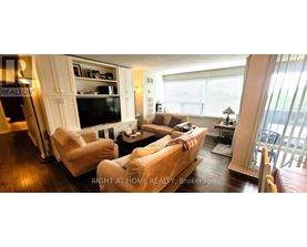 A living room with a couch, chairs, and a television.