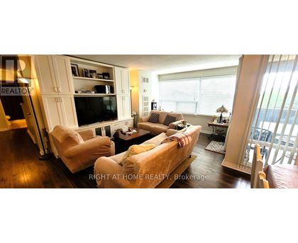 A living room with a couch, chairs, and a television.