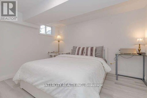 A bedroom with a bed, nightstands, and a lamp.