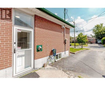 A brick building with a white door and a sign that says Intercity Realty Inc. Brokerage.