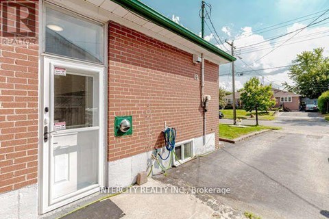 A brick building with a white door and a sign that says Intercity Realty Inc. Brokerage.