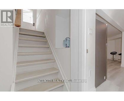 A staircase in a house with a logo of Intercity Realty INC. Brokerage on the wall.