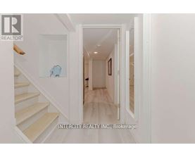 A hallway with white walls and a wooden floor.