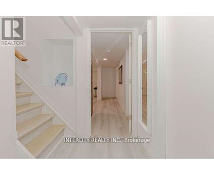 A hallway with white walls and a wooden floor.