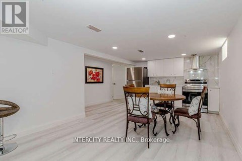 A dining area with a table set for two and a bar stool.