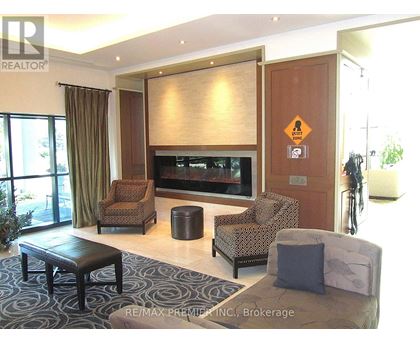 A living room with a brown sofa, a black coffee table, and a television.