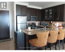 A kitchen with a refrigerator, microwave, oven, and sink.